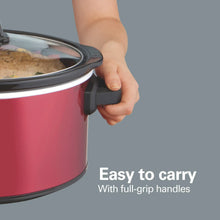 Red slow cooker with side handles, hand gripping to lift the pot.