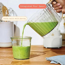 Drew Barrymore 3-cup food chopper pouring green blend from clear container