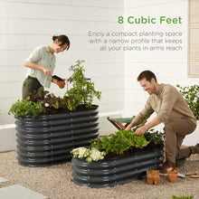 Charcoal oval raised garden bed planter with potted plants in outdoor yard
