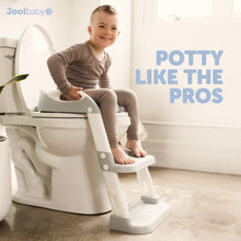 Toddler sitting on a white potty training seat with two-step ladder