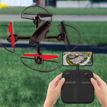 Quadcopter drone on grass with phone live view and remote controller held in hands