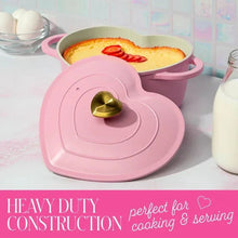 Pink heart-shaped Dutch oven with lid off, handles on sides; oven-safe ceramic interior