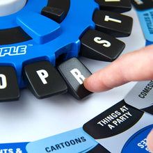Hand reaching for black letter tiles around a blue word-tile spinner board