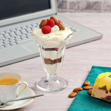 Yogurt parfait in a glass with berries and breakfast biscuits; snack pack at side