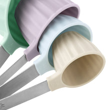 Plastic measuring cups close-up with pastel scoop ends and metal handles