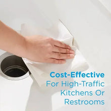Hands pulling a paper towel from a dispenser for high-traffic restrooms