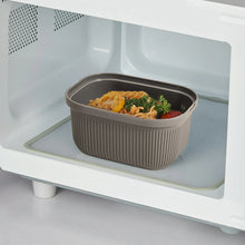 Grey rectangular plastic snack container with lid open, holding pasta and vegetables