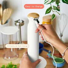 Cordless immersion blender in white icing with charging cable connected