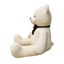 Side view of a seated cream corduroy plush bear with a brown bow tie