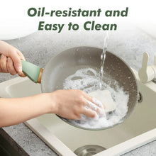 Nonstick skillet with green handle being rinsed with water