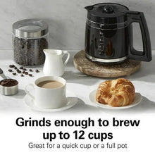 Black electric coffee grinder with clear hopper, plus cups and spoons of grounds