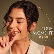 Woman tasting a chocolate truffle with creamy filling