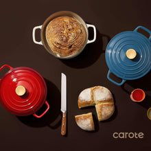Blue enamel Dutch oven with lid, flat lay with bread nearby