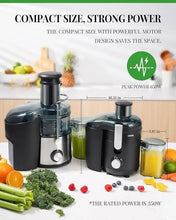 Compact black centrifugal juicer with stainless top and juice cups beside.