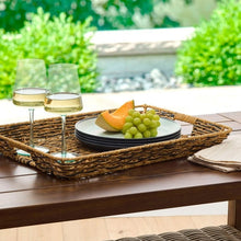 Rectangular woven rattan serving tray with a bowl and fresh grapes on it