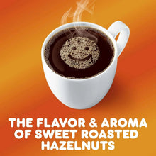 Cup of dark coffee with foam and hazelnut flavor text