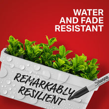 Fine-point permanent marker pointing at text on white planter