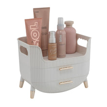 White beauty organizer with open top tray and drawers, showing cosmetics bottles