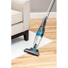 BISSELL stick vacuum with floor nozzle, cleaning under a couch on wood flooring