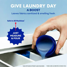 Laundry sanitizer pour into washing machine with blue measuring cup in hand
