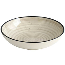 Cream stoneware bowl/plate with black rim and concentric swirl ridges