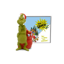 Green Grinch tonie figurine holding red stocking beside story card