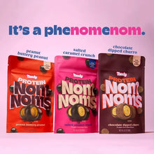 Three Tandy Protein Noms pouches showing peanut butter, salted caramel, and churro flavors