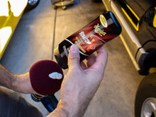 Hand holding Meguiar’s Scratch-X scratch remover over a red foam polishing pad