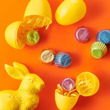 Assorted wrapped mini peanut butter cups with yellow egg-shaped shells and candies