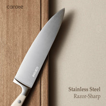 Stainless steel chef knife with light handle resting on wooden block
