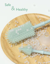 Light green bottle brush and foam bristles with cleaning foam on a plate