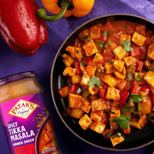 Tikka masala simmer sauce in a bowl with vegetables, with sauce bottle in corner