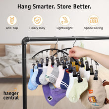 Non-slip legging hanger clips on curved black rack, organizing hanging garments