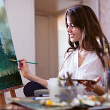 Paintbrushes with long handles held while painting, bristle tips visible