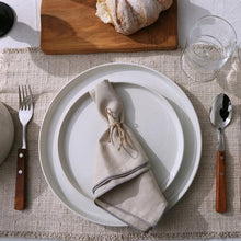 White stoneware dinnerware set with stacked plates and a folded napkin