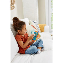 Young child sitting on couch holding VTech Bluey ring phone with lit screen