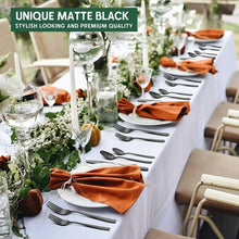 Matte black forks and knives on a table setting with plates