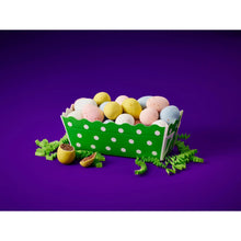 Milk chocolate mini eggs spilling from a green polka-dot bag