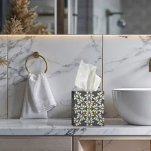 Patterned facial tissue box on bathroom counter with tissues protruding