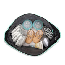 Open black diaper tote with monkey-print top and mint trim, packed with baby bottles