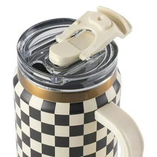 Clear dual-straw lid with beige straw pieces, mounted on a cream-and-black check tumbler