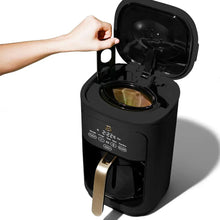 Black drip coffee maker with open lid and visible filter basket and brew tube.