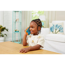 Child lying on the floor smiling while holding a Bluey ring phone toy