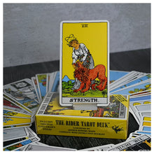 Strength tarot card from Rider-Waite deck, shown upright among cards