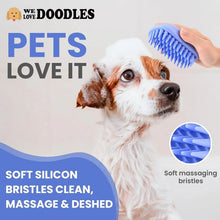 Blue silicone dog bath brush with soft massage bristles held above a white-brown dog