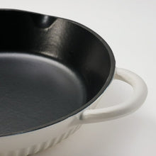 White enameled skillet close-up, black interior pan with white side handle