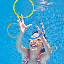 Children playing in a pool with multiple multi-color sparkly dive rings
