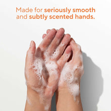 Foamy hands lathered with hand soap, showing soft peach-toned bubbles