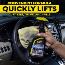 Meguiar's Ultimate Interior Detailer spray bottle and microfiber cloth, car steering wheel area