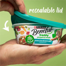 Hand opening a wet dog food tub with resealable lid